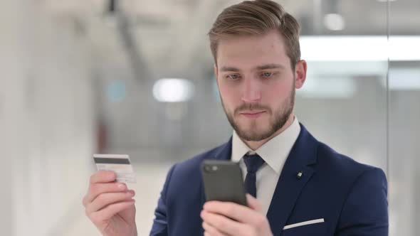 Young Businessman Making Successful Online Payment on Smartphone