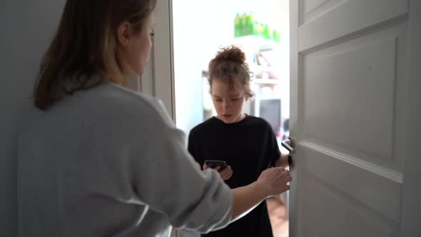 Schoolgirl with a Phone in Her Hands Slams the Door in Front of Her Mother
