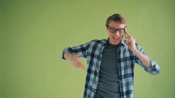 Portrait of Happy Male Student Talking on Mobile Phone Gesturing and Smiling