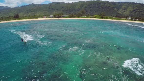 Aerial view of a man kitesurfing in Hawaii.