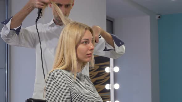 Lovely Young Woman Smiling While Getting Her Hair Styled By Hairdresser