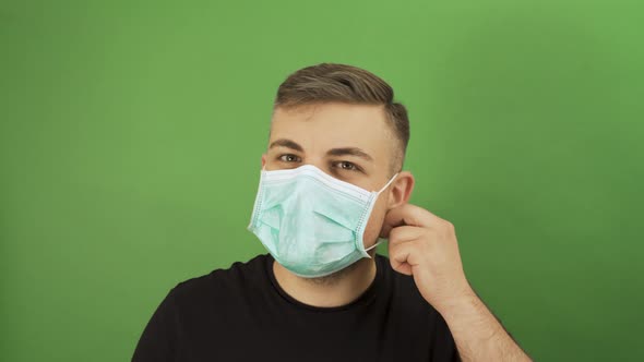 Caucasian Man Taking Off Protective Face Mask and Smiling