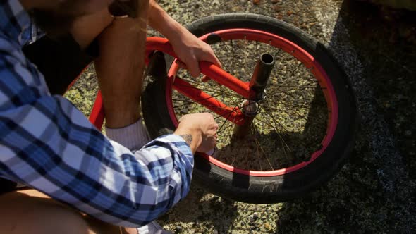 BMX rider repairing wheel