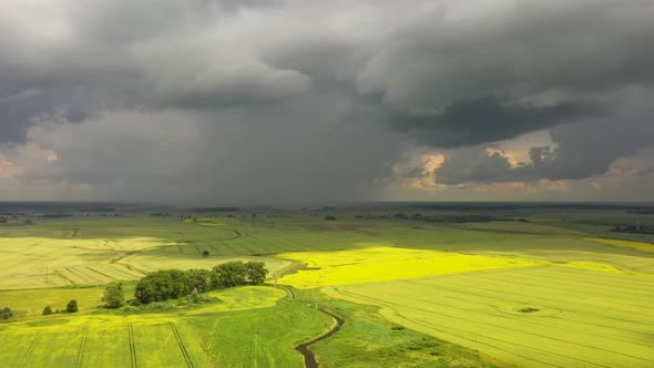 The storm clouds over the agricultural fields, view from a drone