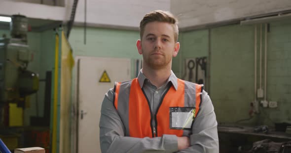 Caucasian male factory worker at a factory wearing a high vis vest