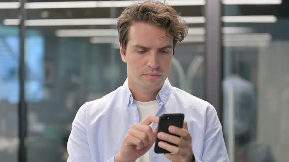 Portrait of Man Celebrating on Smartphone