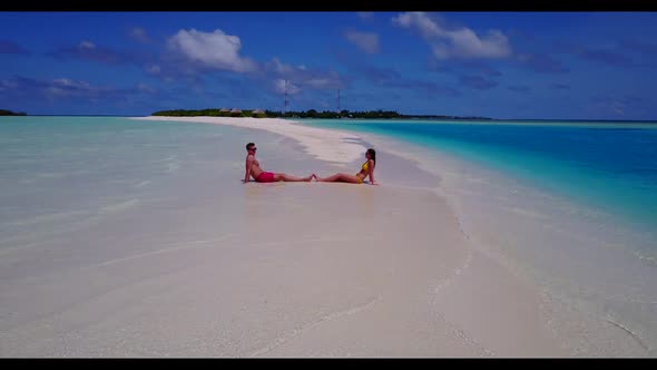 Young couple sunbathing on beautiful sea view beach lifestyle by shallow ocean with white sandy back