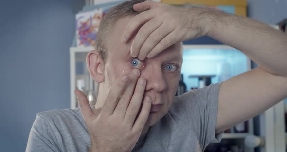 Man Inserting Clear Transparent Contact Lens in Eye