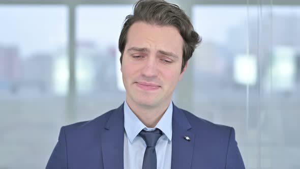 Portrait of Disappointed Young Businessman Crying in Office 