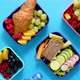 Shot of School Lunchboxes with Various Healthy Nutritious Meals on Blue Background - VideoHive Item for Sale