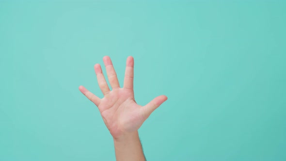 Close up of human hand raising, show hand gesture counting down number by fingers in blue screen.