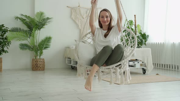 Woman Sitting at Home Swinging on a Swing Sitting at Home