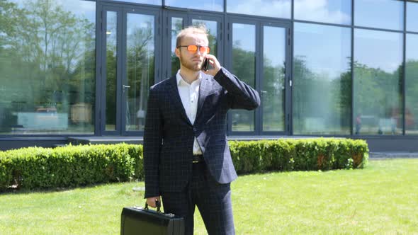 Businessman with Suitcase Walking in a Summer City