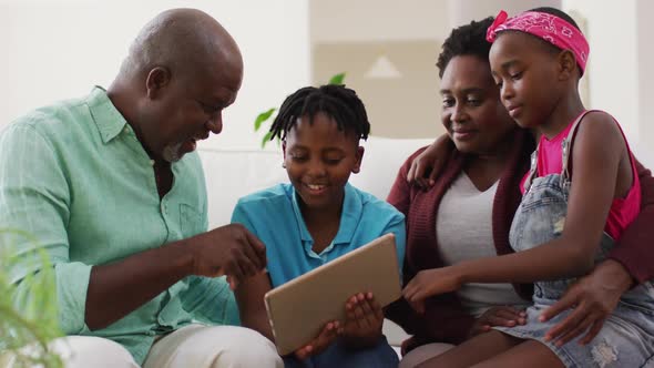 African american grandparents and grandchildren using digital tablet at home