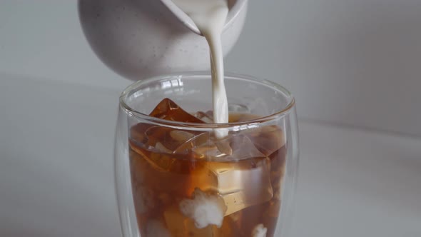 Milk Cream is Poured Into Coffee Iced Tea