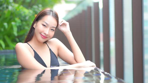 Young asian woman enjoy around outdoor swimming pool for leisure