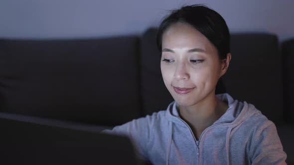 Woman working on laptop computer at night 