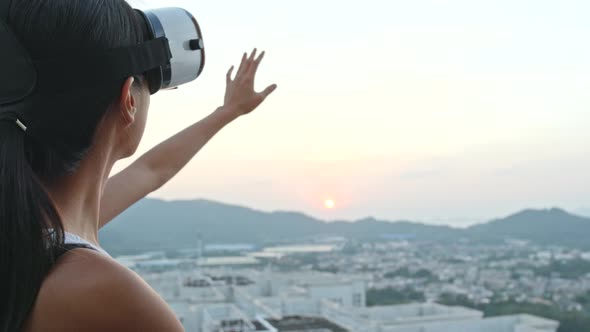 Woman Watching with Virtual Reality Device on Roof Top