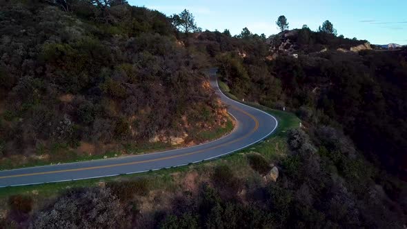 Tight Curve of Mountain Road beside Steep Cliff at Dawn, Drone Orbit