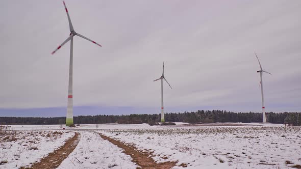 Time lapse of rotating wind turbines on a snowy field in Germany.