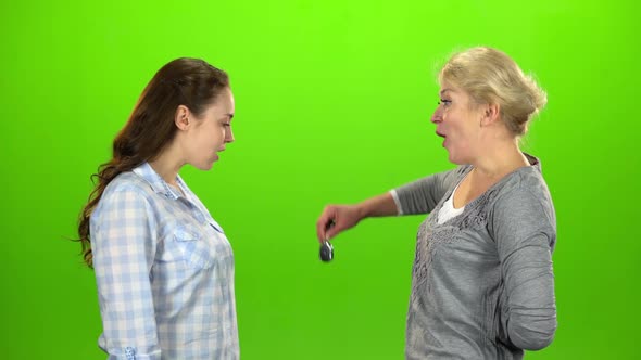 Woman Gives the Keys To Her Daughter. Green Screen. Side View