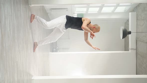 Slow Motion of a Man Performing Elements of Modern Dance in a Bright Studio