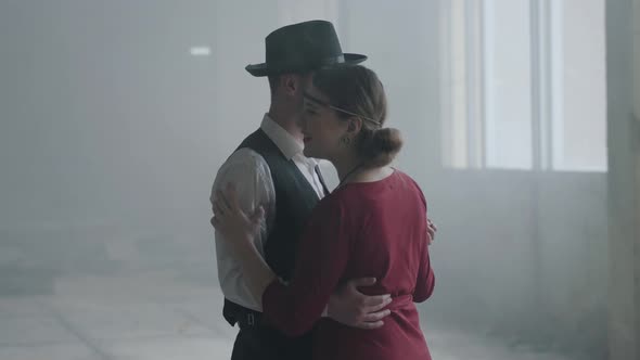 Portrait Man in Fedora Hat, Classical Suits and Woman in Style Cloth Dancing in Abandoned Building.