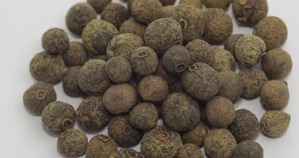 Black Pepper Rotation. Peas with Spices. Macro on White Background