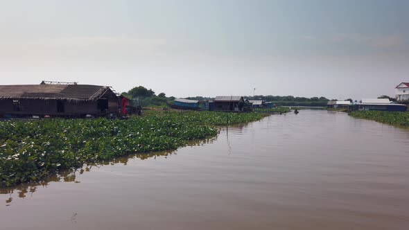 Travelling Down the River Near Tonle Sap in Cambodia Past Floating Houses and Boats