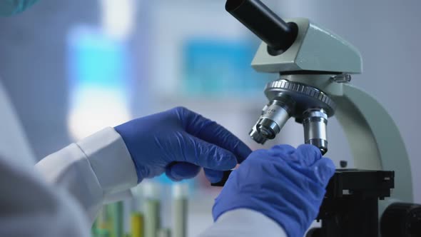 Biochemist Analyzing Sample Through Microscope Glass, Laboratory Diagnostics