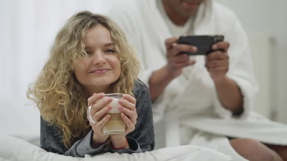Portrait of Happy Charming Young Woman Smelling Morning Cappuccino Smiling As Unrecognizable Man