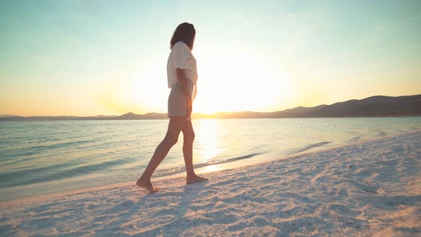 Female Model Walking on the White Sandy Beach of the Clear Tropical Turquoise Sea at Sunset