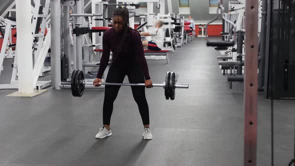 Sports in the Gym  Strong Black Woman Pulling Up a Dumbbell in a Gym