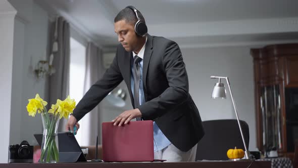 Young African American Man Cleaning Workplace at Home Indoors