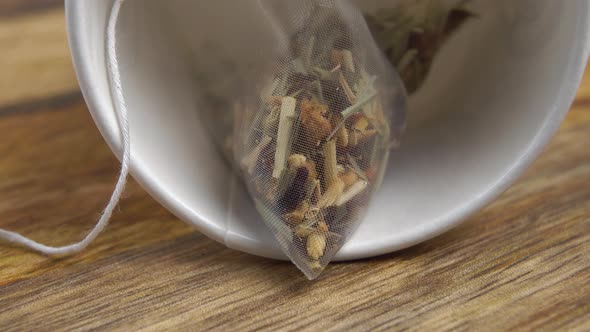 Herbal flower fruit tea in a micro plastic bag in an overturned white cup