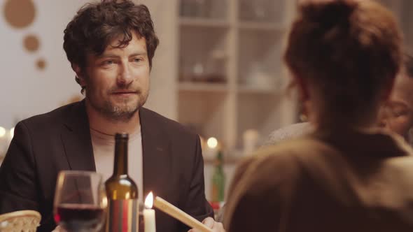 Man Talking with Friends and Posing for Camera at Holiday Dinner