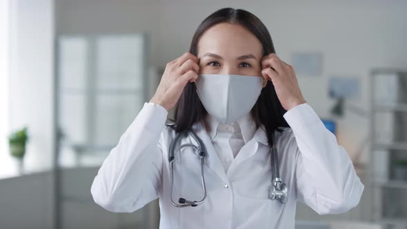Asian Female Doctor Taking Off Mask