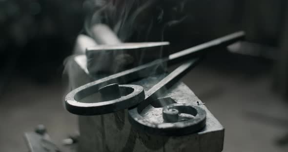 Smoking Forged Metal Rods Lie on the Anvil Next to the Hammer Quench Process Metalwork at Workshop