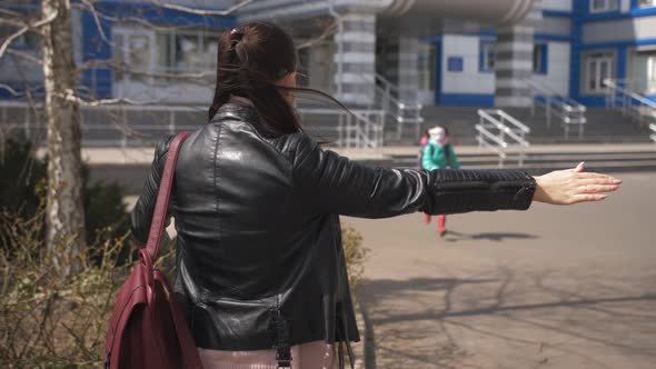 A Mother in a Protective Mask is Waiting for a Little Daughter Firstgrader From School After School