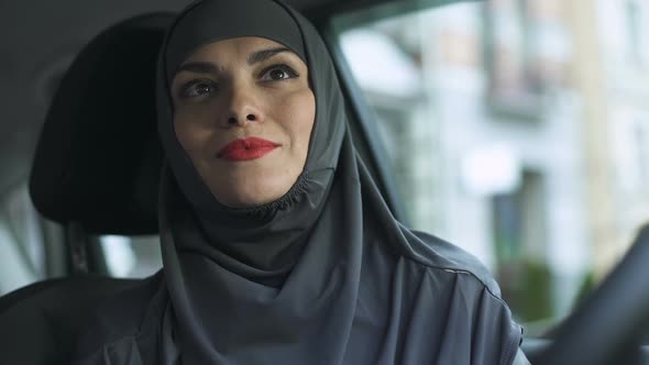 Attractive Sexy Lady in Hijab Applying Red Lipstick in Automobile Feminism, Kiss