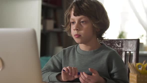 Concentrated Serious Boy Paying Attention To What Teacher on Online Education Tells Spbd