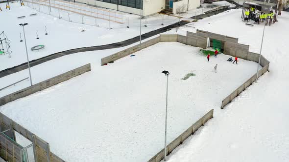 Aerial View Of Five Kids Playing Soccer On Snow-covered Pitch At Wintertime. - ascend