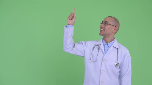 Happy Bald Multi Ethnic Man Doctor Talking While Pointing Up