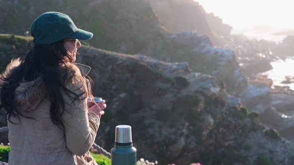 woman drinking yerba mate, typical Argentine drink, on the beach, while watching the sunset pichilem