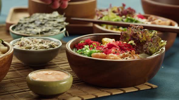 Sprinkling Sesame Seeds on Cooked Poke Bowl Closeup