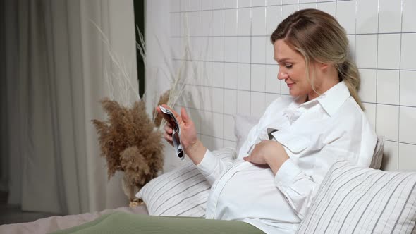 Pregnant Lady Strokes Tummy Looking at Ultrasound Picture