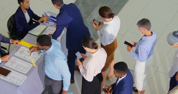 Business people checking in at conference registration table 4k