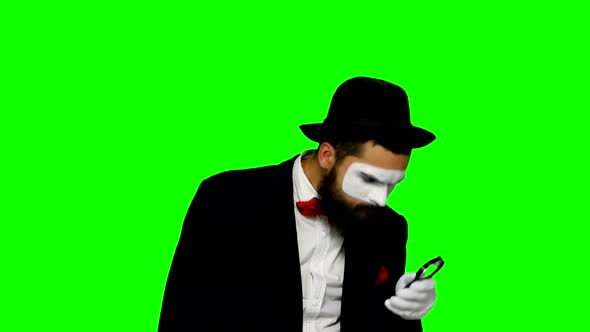 Man Mime Looks Uses Magnifier on Green Screen