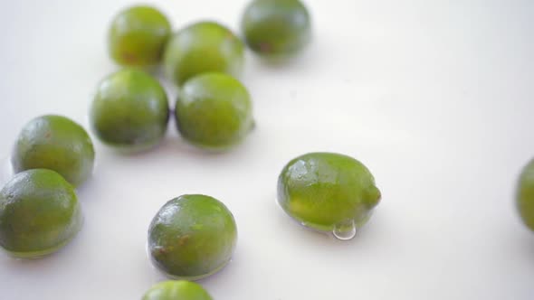 SLOMO of Limes in Water on White Backdrop