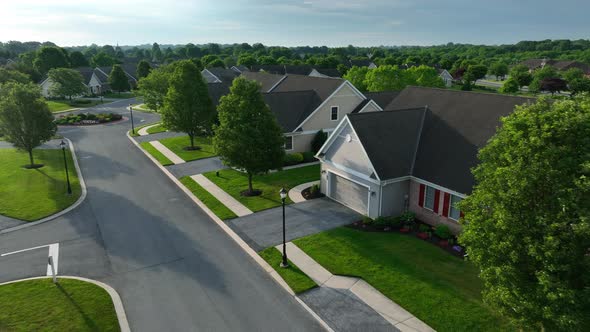 New single story homes in USA with mature trees along street. Senior 55 plus community houses.